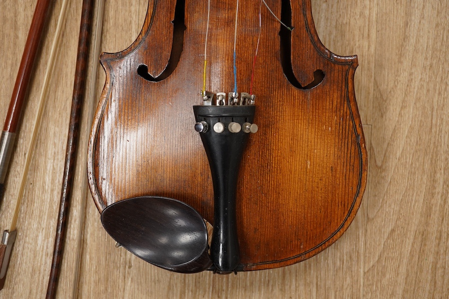 A late 19th century German violin, body 35cm long, and two bows. Condition - poor to fair.